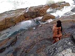 Doğal göğüslü olgun bir Afrikalı kadın plajın önünde sikişiyor