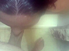 Une femme aux gros seins se nettoie sous la douche et reçoit une éjaculation sur le visage