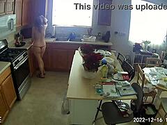 Modne kunder ser på, mens Lia1616rengør køkkenet i rød bikini