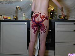 Wanita dewasa dengan tato di pantatnya dengan menggoda memasak makan malam