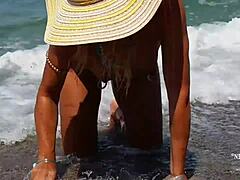 Зрела жена са истегнутим пирсингом на брадавицама и више пирсинга на плажи