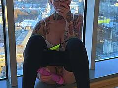 En tatuerad kvinna fingrar sig själv och får en intensiv orgasm när hon är på besök hos vänner
