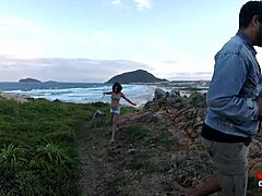 Spennende video av en ung jente som gir en blowjob på steinene ved sjøen